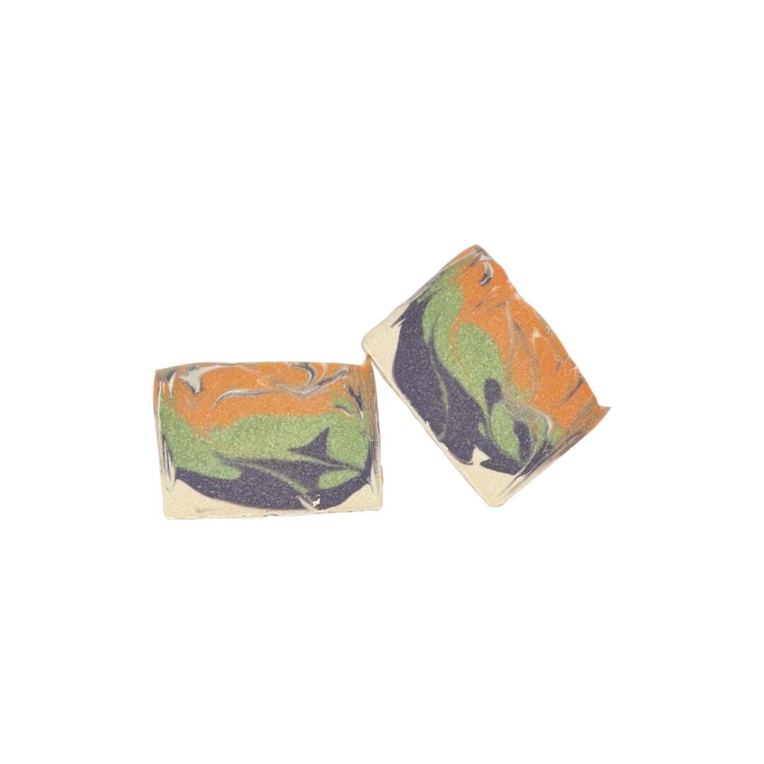 Two Pumpkin Spice soap bars with a green, orange, and blue swirl pattern on a plain white background.