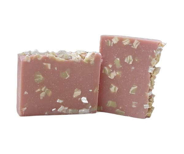 Two bars of pink Japanese Cherry Blossom soap with decorative pieces, one leaning against the other on a plain white background.