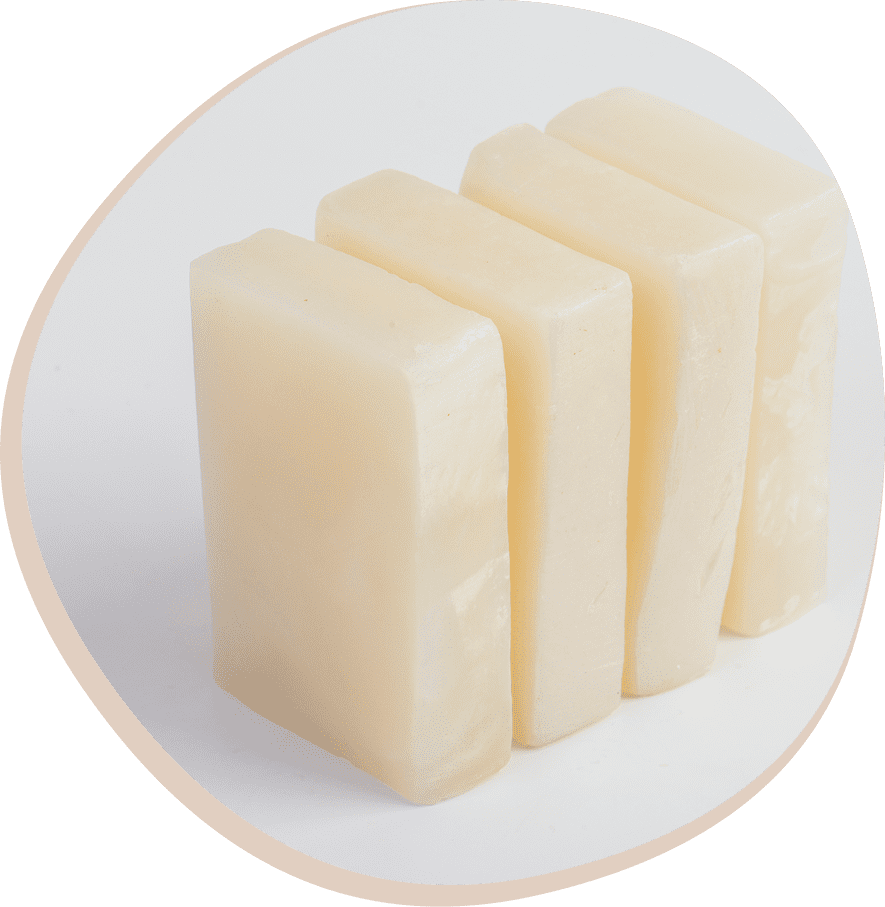 Four rectangular bars of pale soap are arranged upright in a row on a white background.