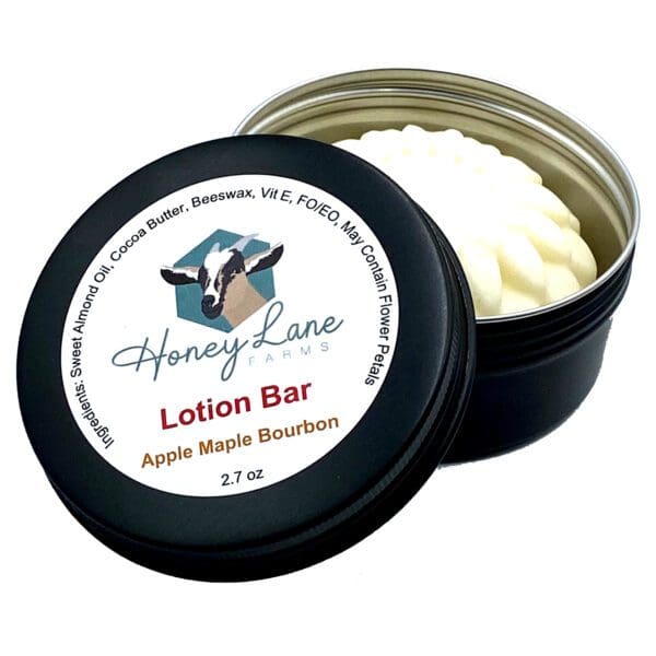 The "Honey Lane Farms" Apple Maple Bourbon Lotion Bar comes in a black tin with a cow logo and includes sweet almond oil and beeswax.