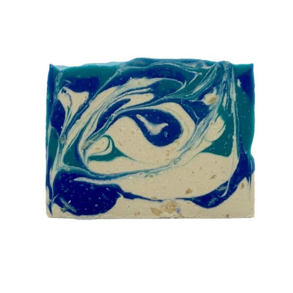 The Barber Shop soap is a rectangular bar featuring swirling patterns in blue, teal, and white.