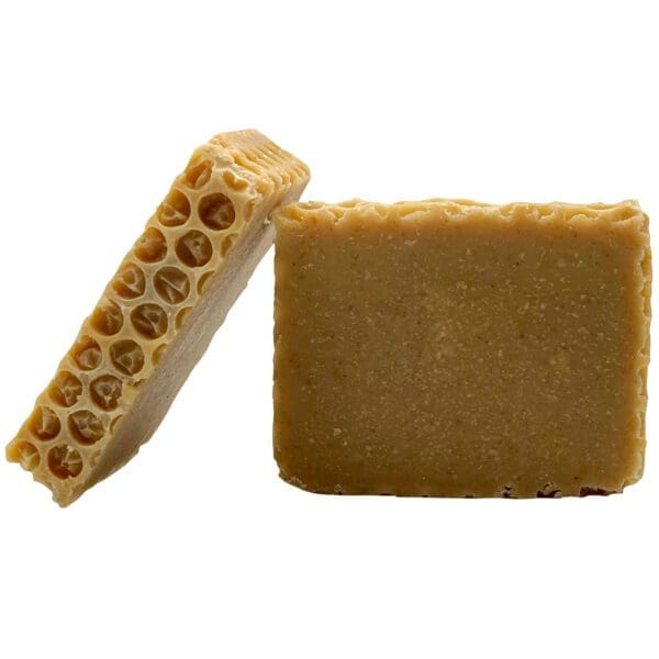 Two Honey Oatmeal soaps, one upright and the other leaning on it, display their textured honeycomb-patterned surfaces.