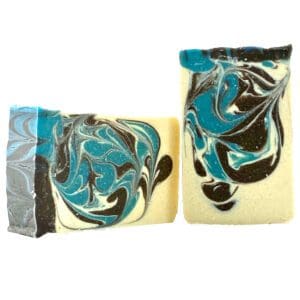 Two bars of Journey soap, featuring marbled black, blue, and white swirls, are positioned upright and leaning against each other.