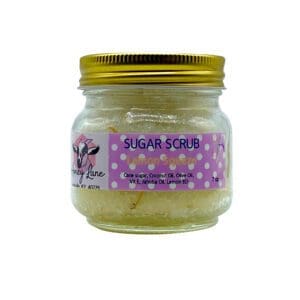 A 7 oz glass jar of "Lemon Squeeze Sugar Scrub" with cane sugar and oils, featuring a cartoon goat on the label.
