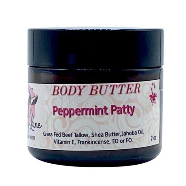A 2oz black jar of Peppermint Patty Body Butter features grass-fed beef tallow, shea butter, and essential oils, with a white and pink label.