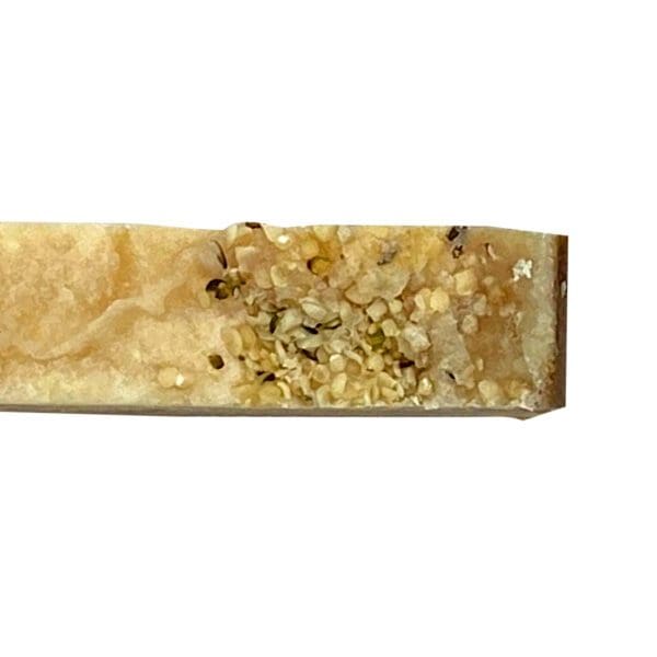 A slice of Spring Rain honeycomb on a white background reveals golden honey and intricate hexagonal wax cells.