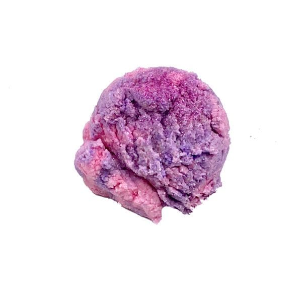 A scoop of Unicorn Bubble Truffle ice cream, displaying purple and pink hues, set against a white background.