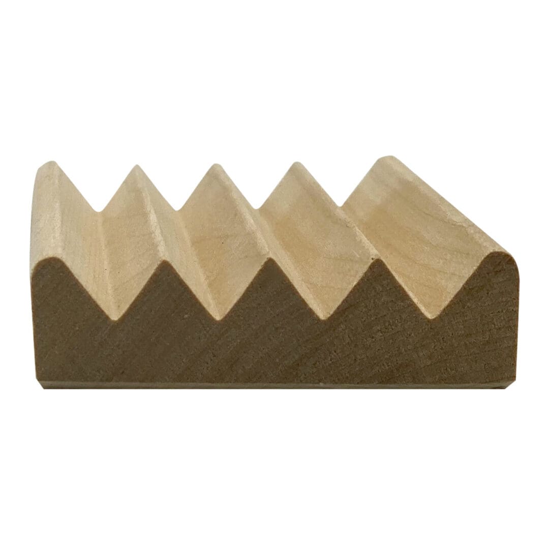 A small item made of wood featuring four triangular peaks and a flat base, similar to a ridged block, is called the Wooden Spike Soap Dish.